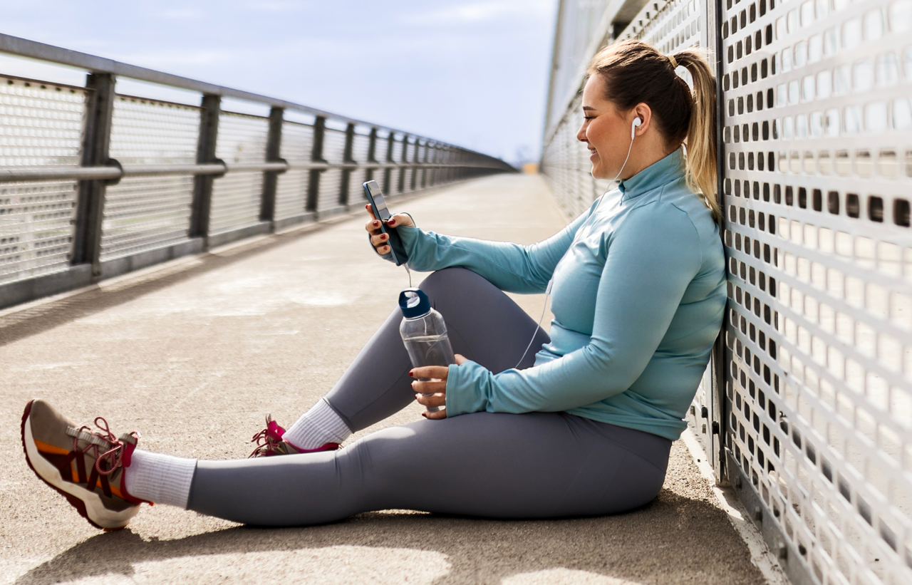 Woman resting on a bridge looking at her phone